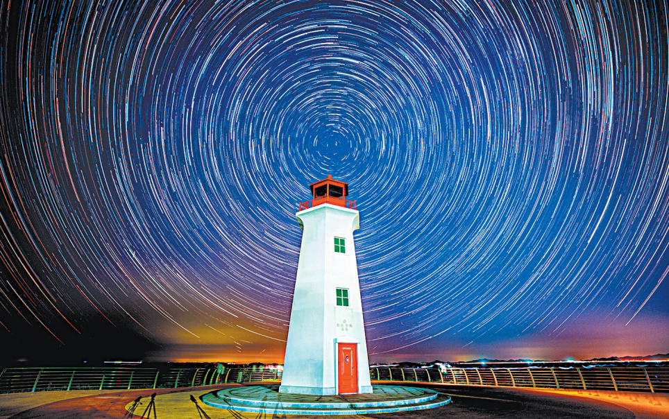 以灯塔为前景拍摄星轨