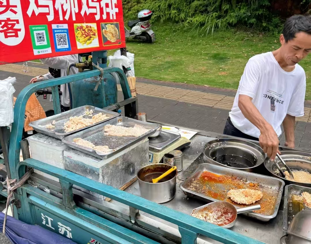 6 元鸡排引疯抢！鸡排哥累到表情失控，从笑出月牙到 “生无可恋”，原则却没掉线