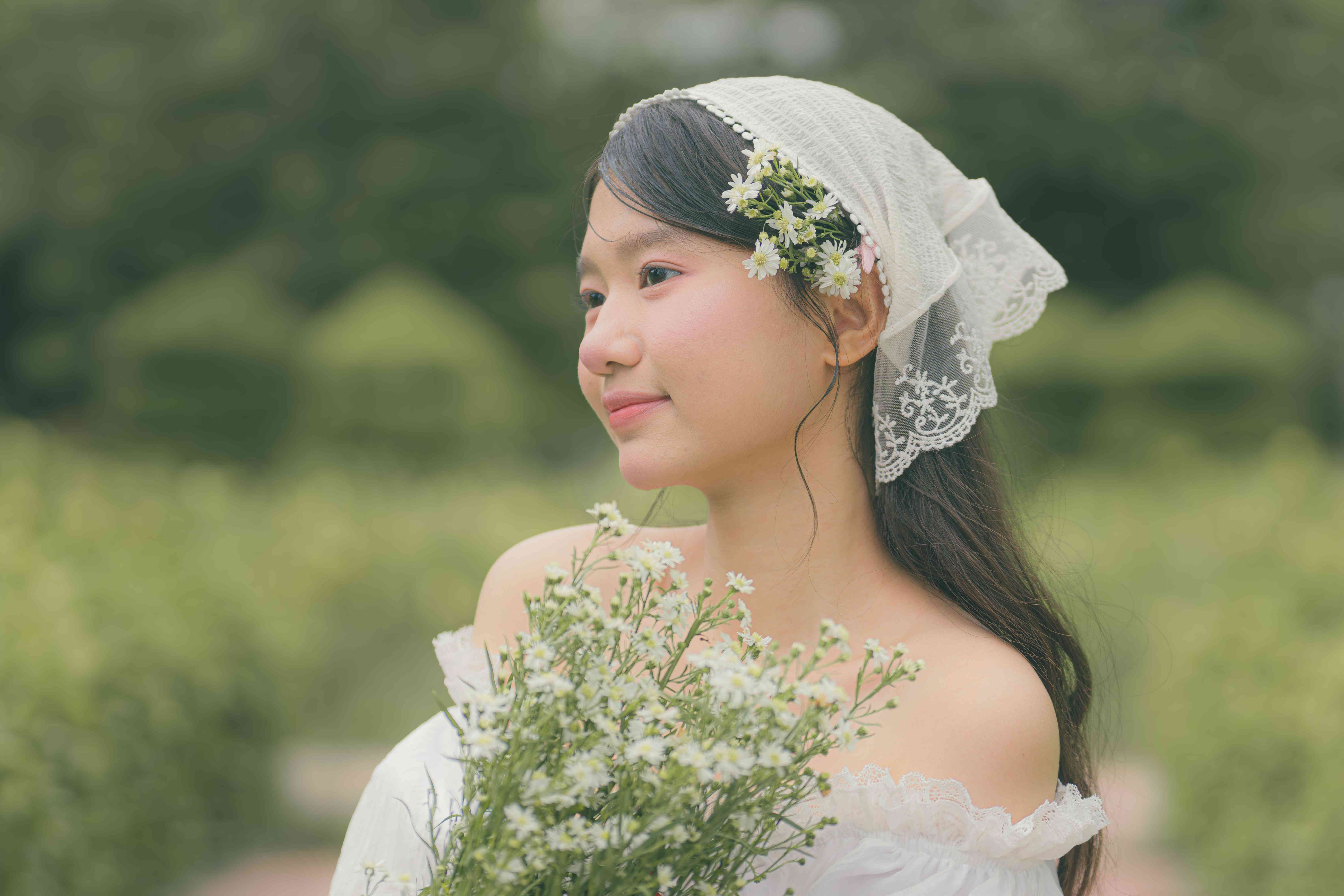 朦胧绿植虚化远景，清甜恬淡神态，全白穿搭与绿野相融，画面干净素雅