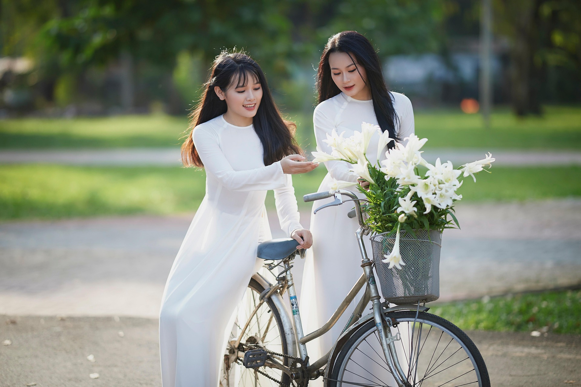 绿树林荫虚化烘托柔和氛围，温婉恬淡互动神态，全白长裙飘逸素雅，自带静谧治愈东方氛围感
